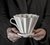 Mãos segurando um Coador de Café em Cerâmica Branco que usa filtro papel 102 Melitta ou filtro de pano 102 da Felline Cerâmica