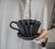 Mão segurando um Mini Coador de Café Individual Preto em Cerâmica que usa filtro de pano 100 Felline ou filtro de papel 100 Melitta