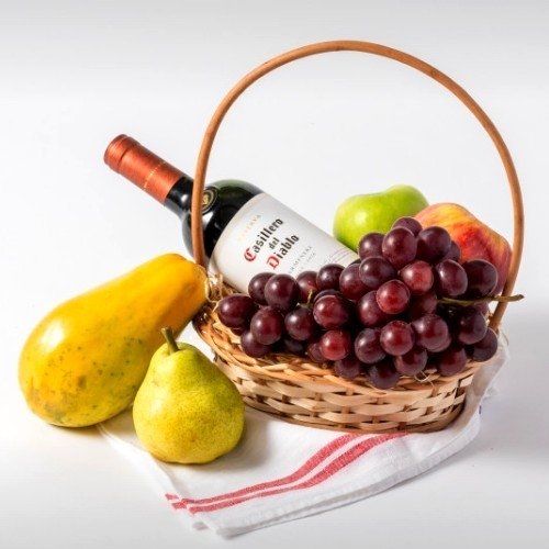 Saca-rolhas elétrico em uma cesta de piquenique na cesta estão baguetes de  frutas, uma garrafa de vinho e chamomi