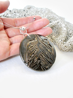 Medallón cobrizo en gargantilla con hematita y plata - Deka Cerámica