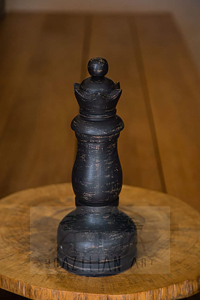 rainha de xadrez de madeira pendurada em uma corda branca com