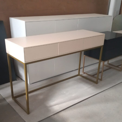Vista a 45° hacia la derecha del mueble escritorio modelo Buenos Aires, color arena, cuenta con tres cajones y una estructura de hierro dorada.