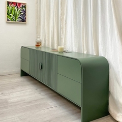 Imagen a 45ª del mueble consola, donde se aprecia la terminación en forma semicircular. El mismo es de color verde.