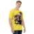 Camiseta amarela em tecido Dry Fit com ilustração da personagem A.k.i. do jogo Street Fighter 6, oferecida pela Kanikoss Moda nerd modelo masculino.