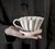 Mão apoiando um Mini Coador de Café Individual Branco em Cerâmica que usa filtro de pano 100 Felline ou filtro de papel 100 Melitta