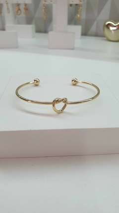 Bracelete aro liso com nó central, em banho ouro 18k.