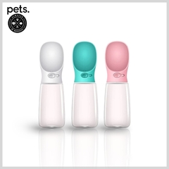 Botellas de agua para perros en colores blanco, verde y rosa con botón de descarga.