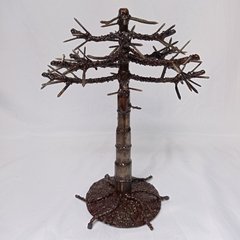 Escultura de uma árvore feita com parafusos e metal, com detalhes em seu tronco e galhos.