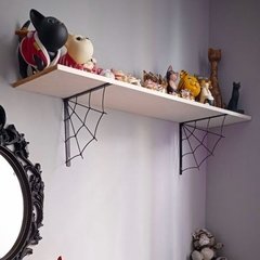 Prateleira com suporte em forma de teia de aranha, decorada com diversos objetos e pelúcias coloridas.