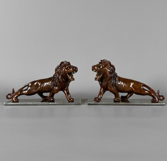 Esculturas de leones en madera tallada y base de hierro