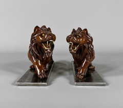 Esculturas de leones en madera tallada y base de hierro