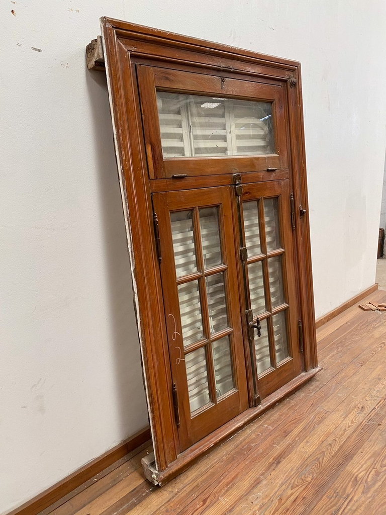 Ventana de madera con celosías de hierro.