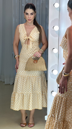 Vestido Elisa Laise Bicolor com amarração, em tom amarelo, com detalhe de padrão e saia rodada, combinado com bolsa de palha.