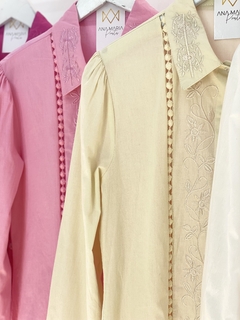 Camisas femininas em diferentes cores: rosa, amarelo e branco, com detalhes bordados e botões de strass.