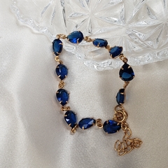 Pulseira dourada com cristais gota azul safira.