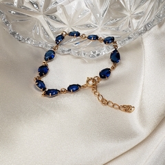 Pulseira dourada com cristais gota azul safira. - comprar online