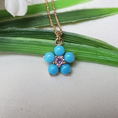 Colar dourado com pingente flor em resina azul claro e zircônia rosa