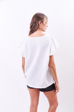 Imagen de Blusa amplia, con flores bordadas blancas y doradas.