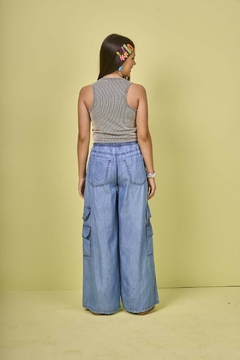 Modelo feminina usando calça juvenil wide leg utilitário em chambray denim, vista de trás.