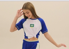 Menina usando uma camiseta cropped azul e branca com a bandeira do Brasil na frente.