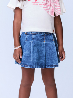 Shorts saia jeans com pregas, modelo feminino, exibido em uma criança.