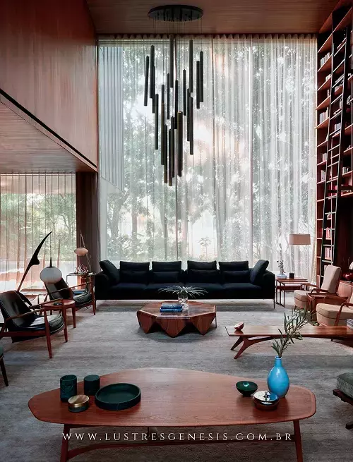 Sala de estar moderna com lustre da Linha Ming Preto, sofá escuro e mesa de centro de madeira.