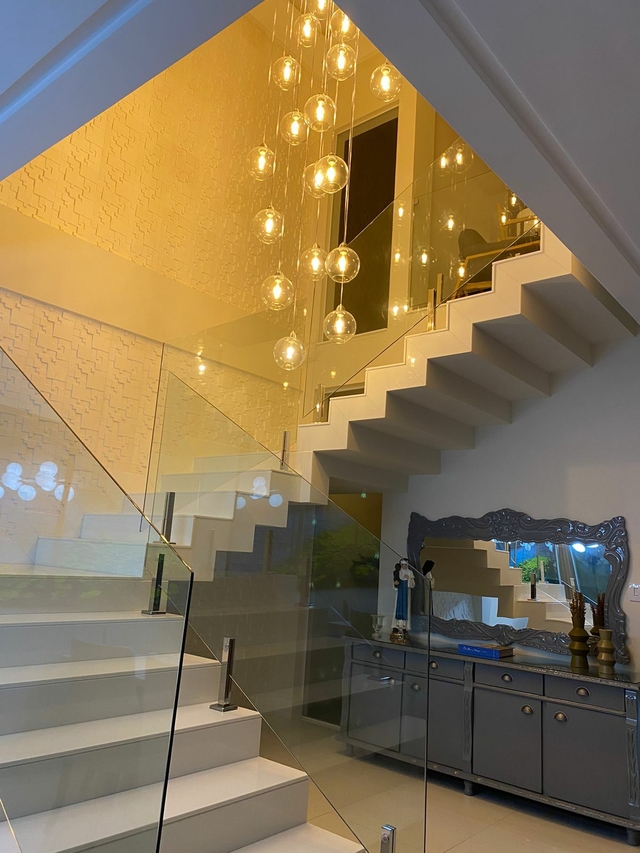 Lustre pendente com várias lâmpadas em vidro transparente, iluminando um ambiente moderno.