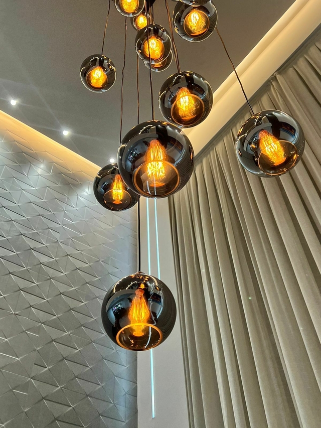 Pendentes da linha Sarvah, com vidro fumê espelhado, iluminando um ambiente moderno.
