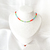 Choker cristais azul, laranja e verde com olho grego ouro