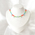 Choker cristais azul, laranja e verde com olho grego e gotas ouro