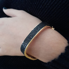 BRACELETE NOVA YORK é uma semijoia com design contemporâneo e atemporal. É banhado a ouro e possui uma metade cravejada de zirconias pretas. É elegante para ocasiões diurnas e noturnas. Semijoia da Allegra.