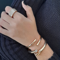 BRACELETE ROMA é uma semijoia com design contemporâneo e atemporal. É banhado a ouro. É elegante para ocasiões diurnas e noturnas. Nesta sugestão, a modelo utiliza o BRACELETE ROMA (próximo à mão) com o ANEL PARIS e o BRACELETE EIFFEL. Semijoias Allegra.