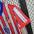 Camisa titular do Atlético de Madrid 24/25 Nike Vermelha com listras brancas e detalhes em azul - Nova camisa Atlético de Madrid listrada 2024 - Camisa Atlético de Madrid gola V Azul 2024.