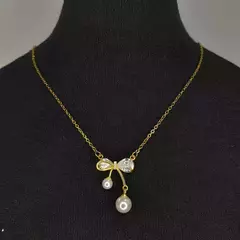 collar con dije moño con strass y perla acero dorado y plateado