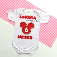 Body infantil branco com detalhes em vermelho, estampado com a Minnie Mouse com perolas vermelhas e douradas nome e meses