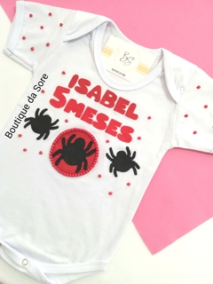 Body de bebê branco com decoração temática do Homem Aranha, para menina com nome e meses em destaque, com aranhas em vermelho e preto e pérolas ideal para festa de mesversario e aniversario