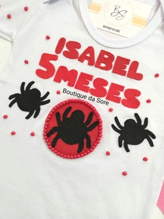 Body de bebê branco com decoração temática do Homem Aranha, para menina com nome e meses em destaque, com aranhas em vermelho e preto e pérolas ideal para festa de mesversario e aniversario