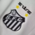 Emblema do Santos Futebol Clube em uma camisa branca, com as estrelas e as datas 1912 e 2012 bordadas.