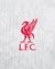 Logo do Liverpool FC em destaque na camisa branca com detalhes em vermelho e cinza.