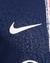 Detalhe do logo da Nike em uma camisa Paris Saint-Germain I 24/25 masculina, azul com detalhes em vermelho.