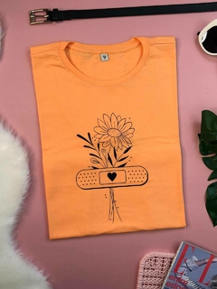 Camiseta na cor laranja com desenho de flores minimalistas preta, tshirt feminina manga curta e gola redonda