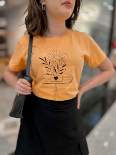 Camiseta na cor laranja com desenho de flores minimalistas preta, tshirt feminina manga curta e gola redonda