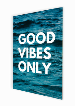 Placa com o dizer good vibes only com oceano azul ao fundo. Em perspectiva.