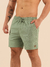 Shorts de linho curto na cor verde, com elástico na cintura e bolso lateral, modelo masculino.