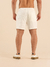 Homem de costas usando shorts curtos de linho off white.