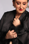 Pijama de luxo em cetim com toque de seda preto, adornado com plumas sintéticas para um toque de ousadia e elegância noturna.