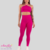 Modelo usando conjunto fitness rosa, composto por top e leggings, em ambiente neutro.