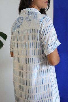 Camisa alongada (Chemise) alegria é divertida, possui modelagem clássica, com gola, colarinho, bolso e mangas curtas. Possui botões em madeira, vira na manga e mix (combinação) de estampas. Confeccionada em viscose estampada nas cores azul e branco. 