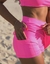 Short Saia fitness na cor rosa com cintura alta, saia evasê e proteção solar. Ideal para beach tennis e academia.