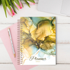 Planner A5 com design em mármore nas cores terra, com a inscrição personalizada.